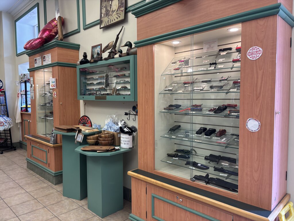 Inside Grohmann Knives in Pictou, glass display cases showcase a variety of handcrafted knives, accessories, and wood products for sale.